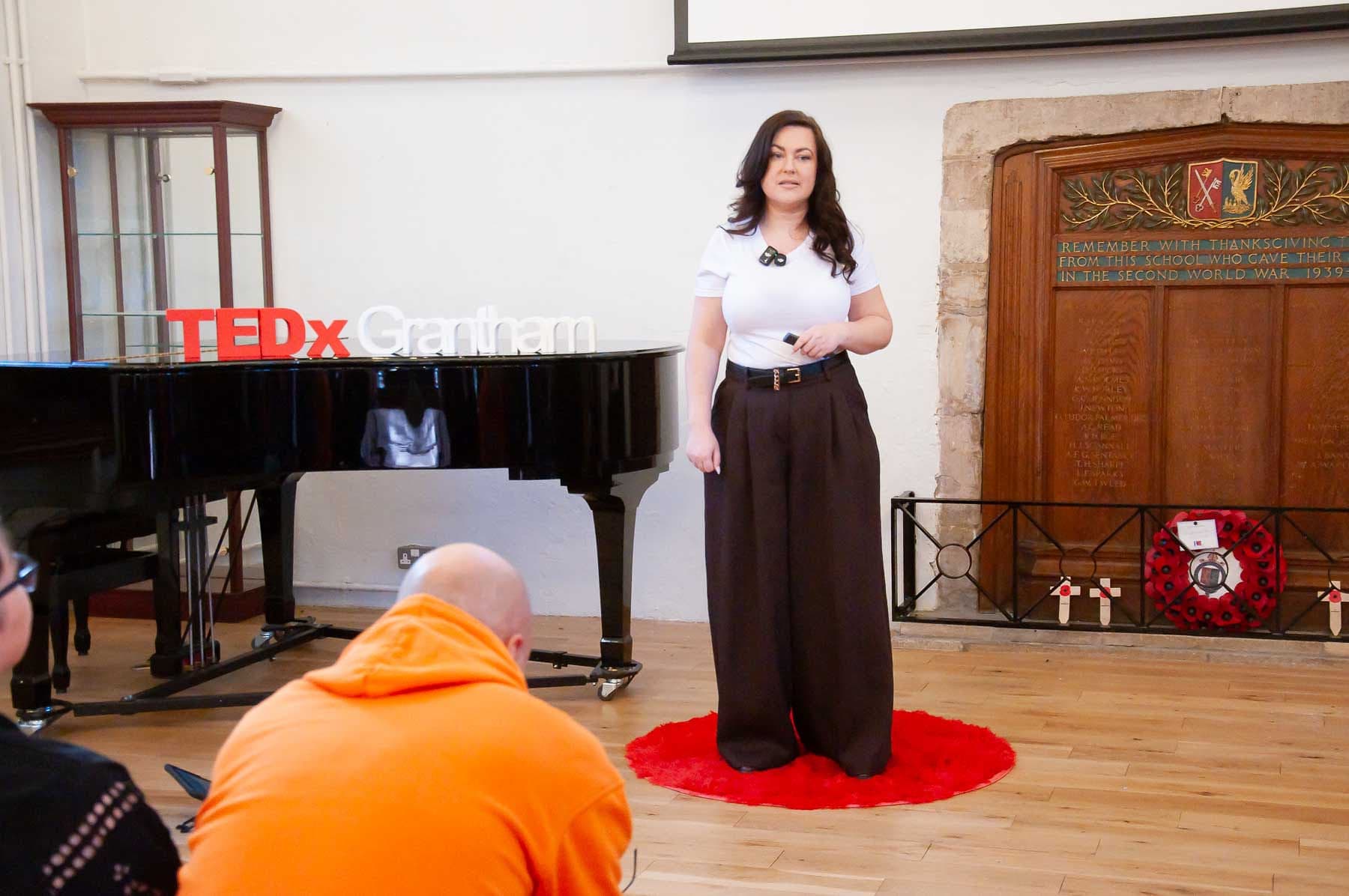 Hannah Worrall presenting beside the piano at The King’s School