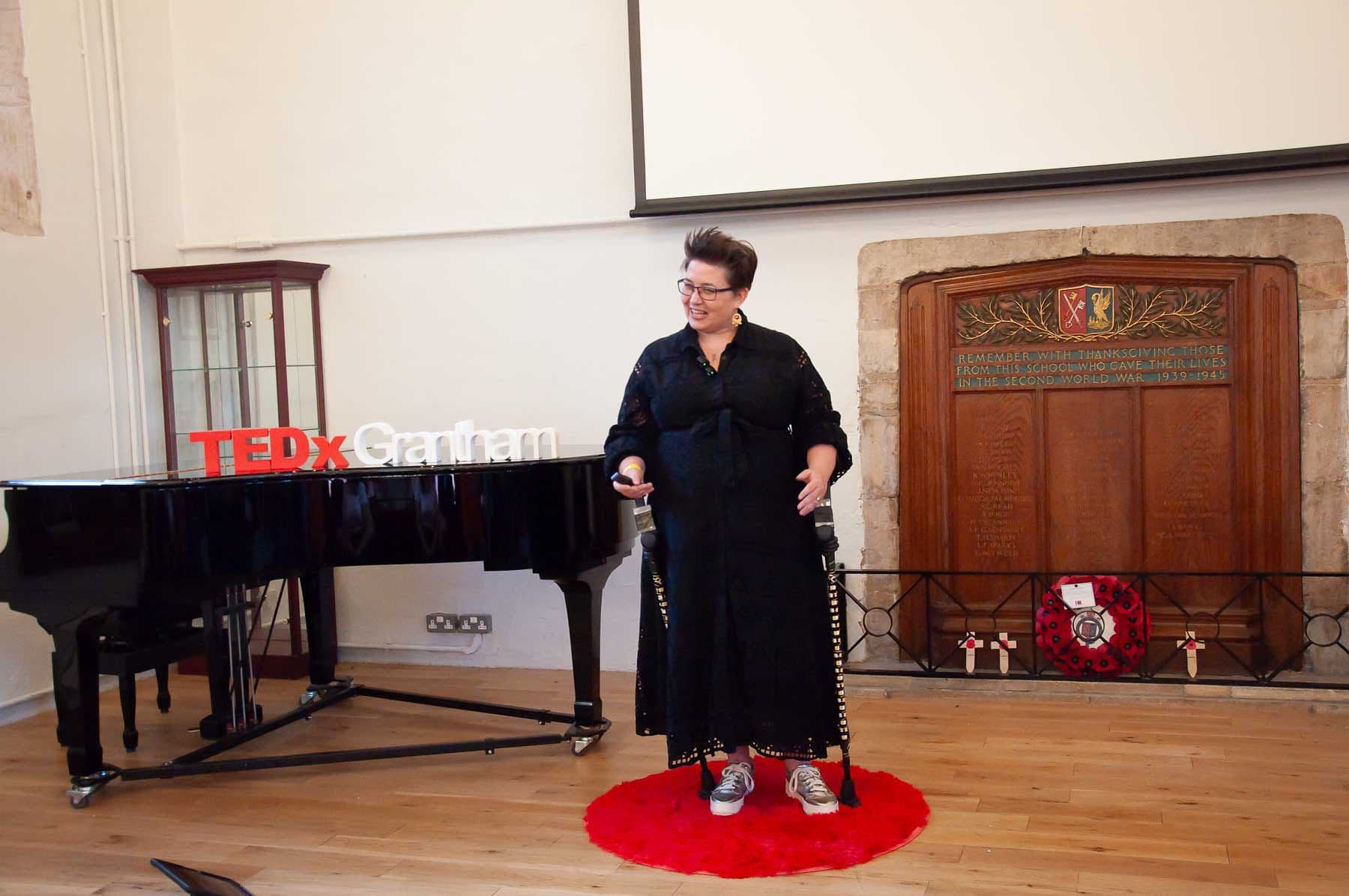 Emma Easton speaking from the red TEDx circle