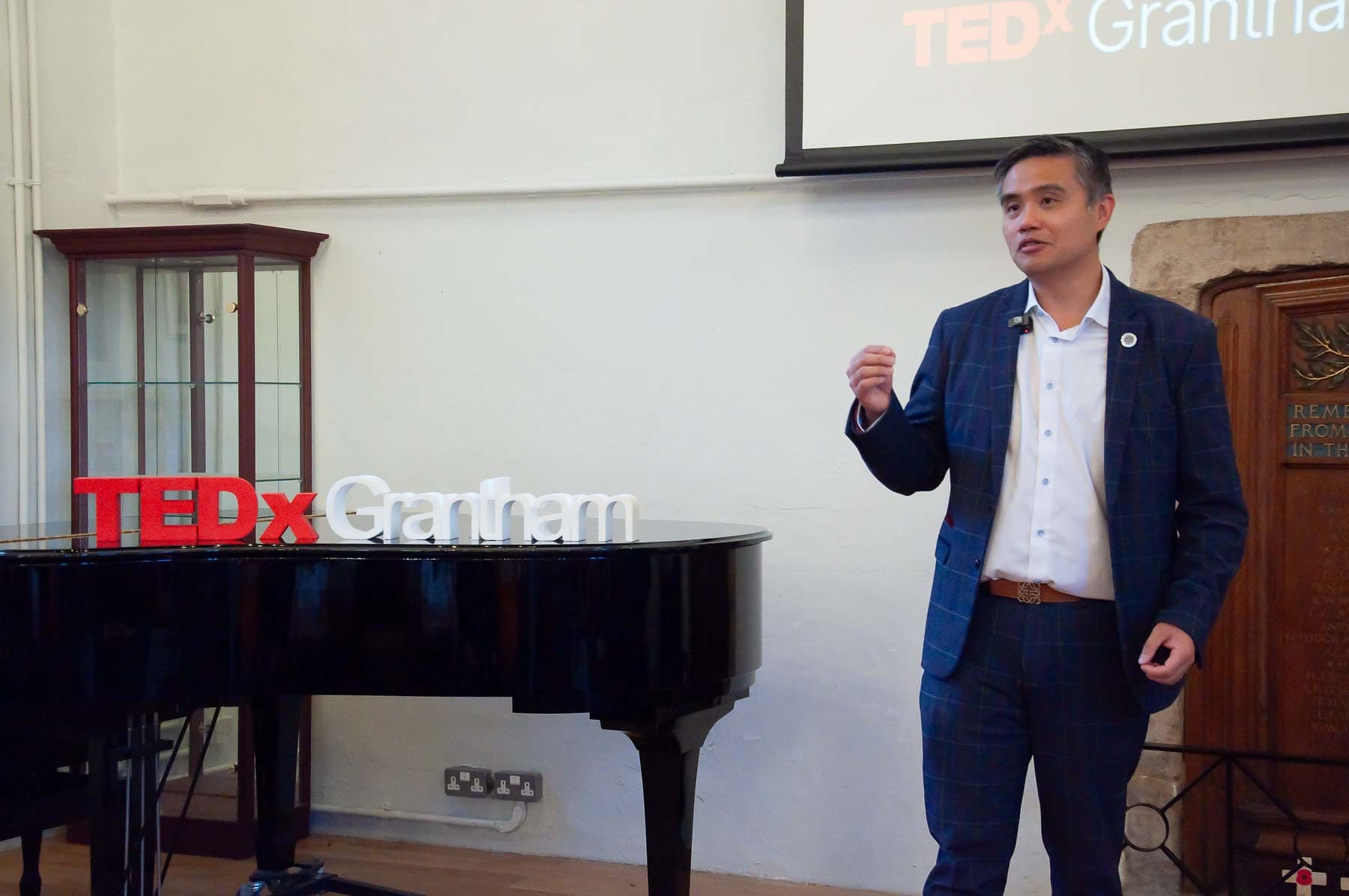 Professor Paul Y. F. Lee presenting beside the TEDxGrantham sign
